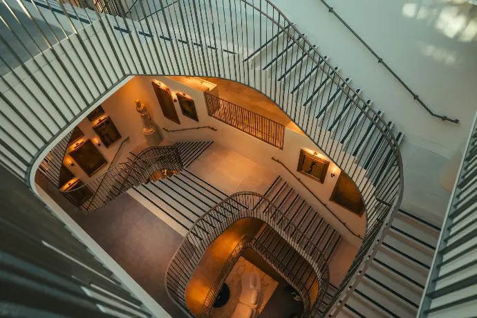 Modern spiral staircase with metal railings and artwork